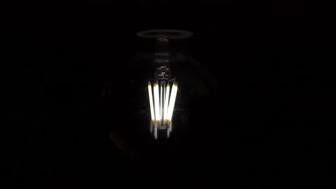 Flickering old retro light bulb on a dark background. Power outage concept. Stock Footage 224076493