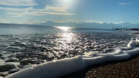 The flickering of the setting sun on the sea waves caressing the picturesque Video stock 264054981