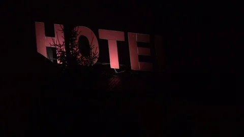 Flickering spooky red hotel sign at night Stock Footage
