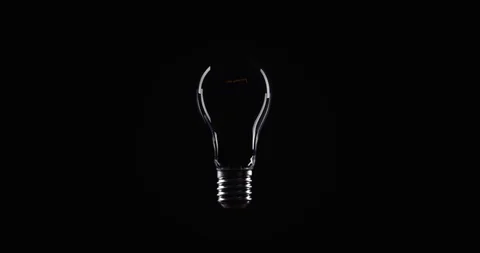 Flickering Tungsten light bulb lamp over black background Stock Footage 101945766