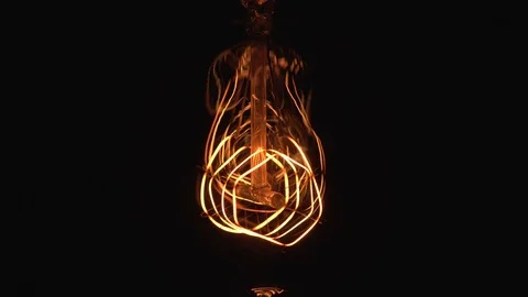 Flickering Tungsten light bulb lamp on black background. Periodic dimming of  Stock Footage 124239797