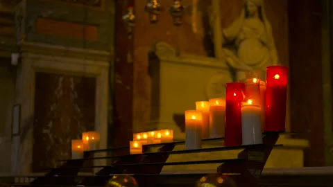 Flickering votive candles burning inside a church Stock Footage 321598577