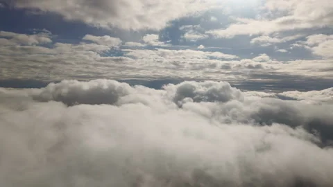Flies high in sky on between two levels puffy clouds. Natural scene with cloudy Stock Footage 339038425