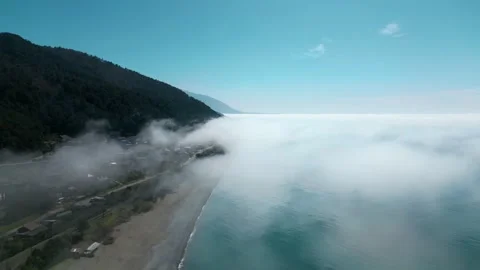 Flight above the clouds against the background of the sea and mountains Stock Footage 270475725