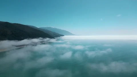 Flight above the clouds against the background of the sea and mountains Stock Footage 270475743