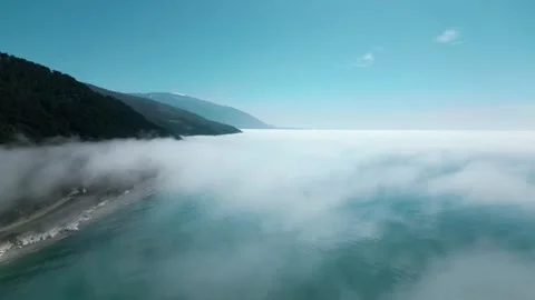Flight above the clouds against the background of the sea and mountains Stock Footage 270476390