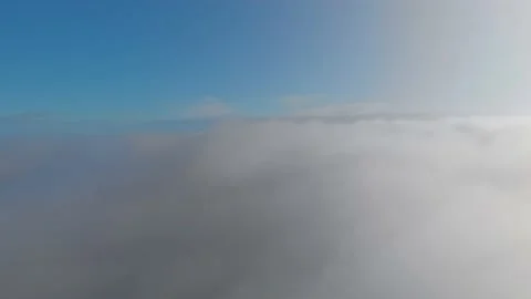 Flight above the clouds to the sun, blue sky with fluffy clouds illuminated by Stock Footage 172394431