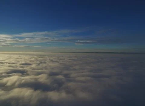 Flight above clouds through the cloudy sky Stock Photos