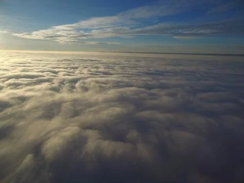 Flight above clouds through the cloudy sky Stock Photos