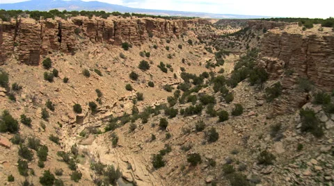 Flight above a dry stream bed in a desert canyon Stock Footage 59334564