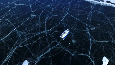 Flight above hovercraft motion on frozen Lake speeding across vast cracked ice Video stock 317487316