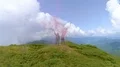 The flight above man and woman with smoke bombs on the mountain top 4k or 4k+ Resolution