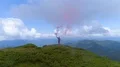 The flight above man with smoke bomb on a mountain top 4k or 4k+ Resolution