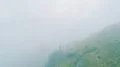 The flight above a man standing on a mountain cliff 4k or 4k+ Resolution