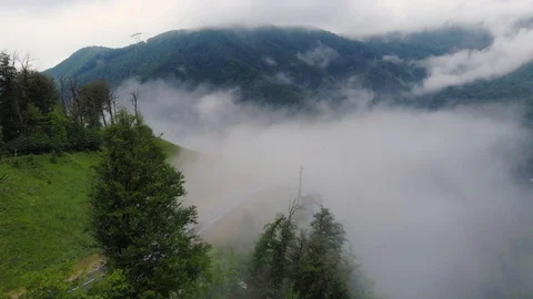 Flight above mountain road over low clouds Stock Footage 108745628