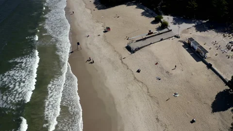 Flight Above A Sandy Beach With Pier Full Of Walking People Stock Footage 143853631