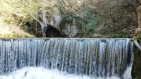 Flight above small waterfall trough the shadow toward the spring in side cave Stock Footage 106158523