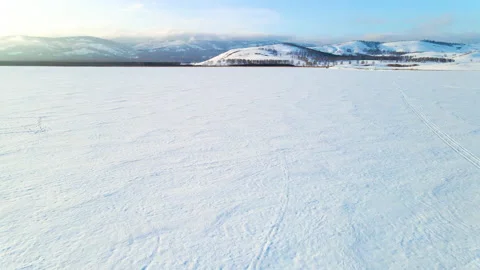 Flight above snow-covered winter lake at sunset Stock Footage 150077445
