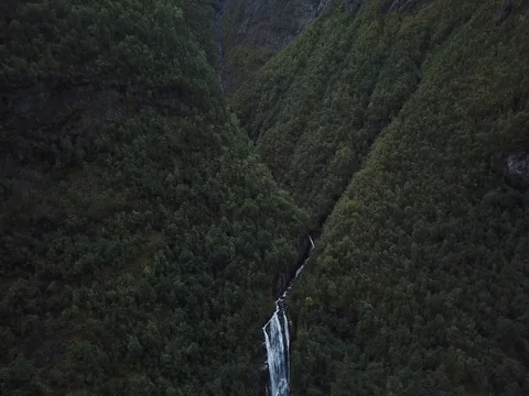 Flight above a Waterfall and Stream descending from Steep Cliffs Stock Footage 80990783
