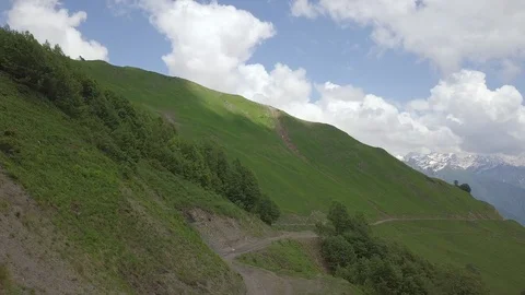 Flight above the way under the green hill of mountain Stock Footage 101069992