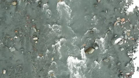 Flight along a cold shallow mountain river. A stormy stream flowing through the Vidéo 153786321