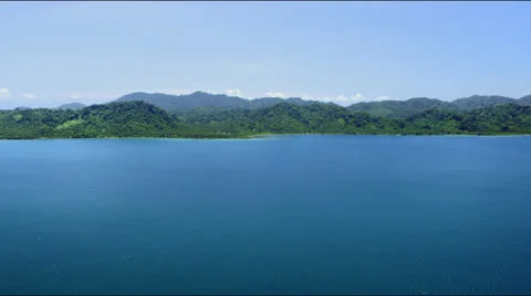 Flight along a distant forrest covered coast line Video stock 25363556