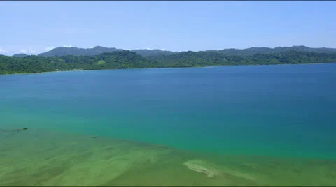 Flight along a distant forrest covered coast line Stock Footage 25363944