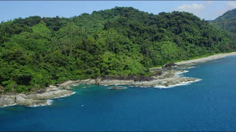 Flight along a forest covered hilly coast line Stock Footage 25360092