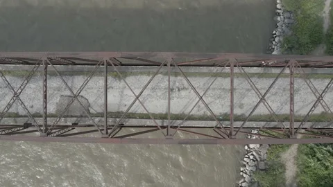 Flight along the old bridge. Old metal arch bridge. Dirty river. Stock Footage 138196173