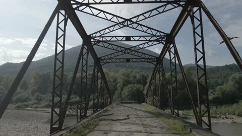 Flight along the old war-destroyed bridge. Old metal arch bridge. Stock Footage 138195317