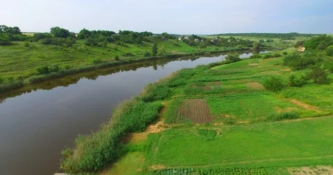 Flight along the river and green fields next to a small village Video stock 89683876