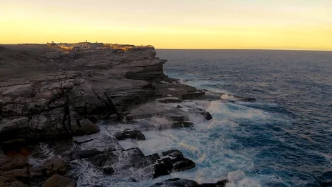Flight along the rocky coastline with waves crashing into them at Sunset. 4K 動画素材 106322853
