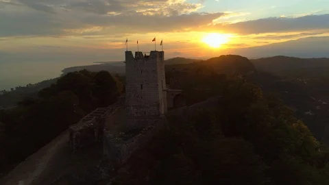 Flight Anacopia Fortress stone tower orange sunset stronghold New Athos Abkhazia Stock Footage 128277657