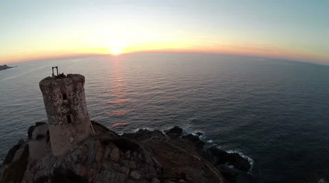 Flight and takeoff over old tower at sunset. Corsica, France. Aerial view. 動画素材 47481519
