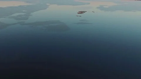 Flight and takeoff over wild frozen lake in winter on sunset, aerial view. Stock Footage 70375616