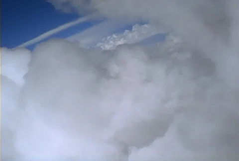 A flight around puffy white cloud formations banks sharply to the right, Stock Footage 86881788
