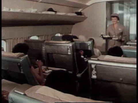 A flight attendant serves dinner to passengers at the first class section during Stock Footage 75300720