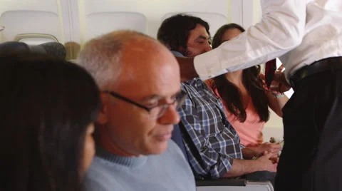 Flight attendant serving passengers on plane Stock-Footage 67344834