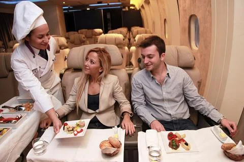 Flight attendants, before flight, proofing services to passengers Stock Photos