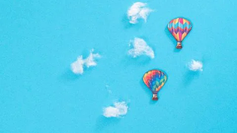 Flight of balloons in the clouds, blue background with space for text Stock Photos