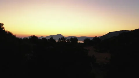 Flight from behind a crest of a cliff overlooking the bay. Dokos Island, Greece. Stock Footage 131015134