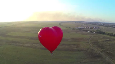 Flight of behind the red hot air balloon in the shape of heart. Aerial view Stock-Footage 41717671