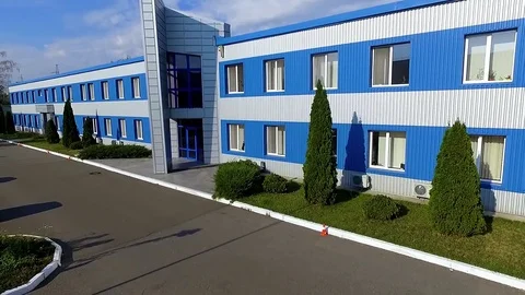 Flight beside warehouse storage building blue facade exterior HD aerial video Stock Footage 72219295