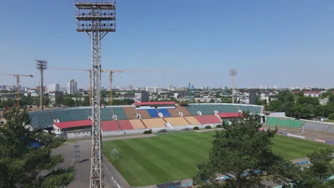 Flight between tree branches towards the stadium. Football stadium in the cit Stock Footage 156370519