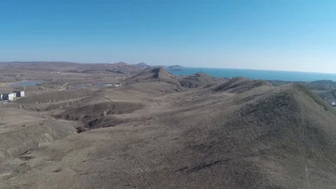 Flight of the camera over a hillside over a coastal village to the sea Stock Footage 91396388