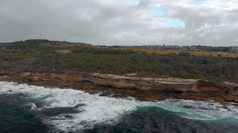 Flight with camera pan along a rocky coastline during cloudy weather 4K 動画素材 105526235