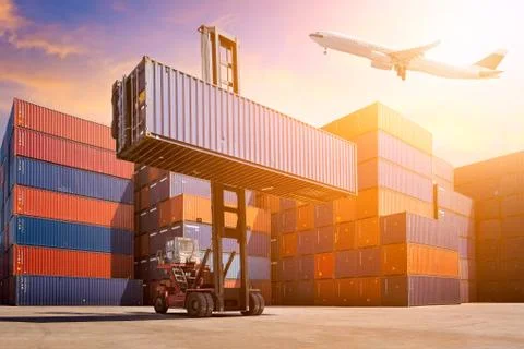 Flight cargo flying over Logistic cargo container in shipping yard. Stock Photos