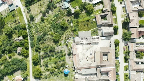 Flight with a circular motion above a constructon site in a small village Stock Footage 137252700
