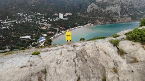 Flight close over man in raincoat controlling drone to sea Video stock 103180792