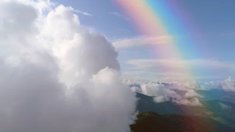 The flight in clouds above mountains on a rainbow background. Hyperlapse 库存影片 112742486